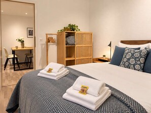 Una camera d'albergo con un letto, una scrivania e un armadio.