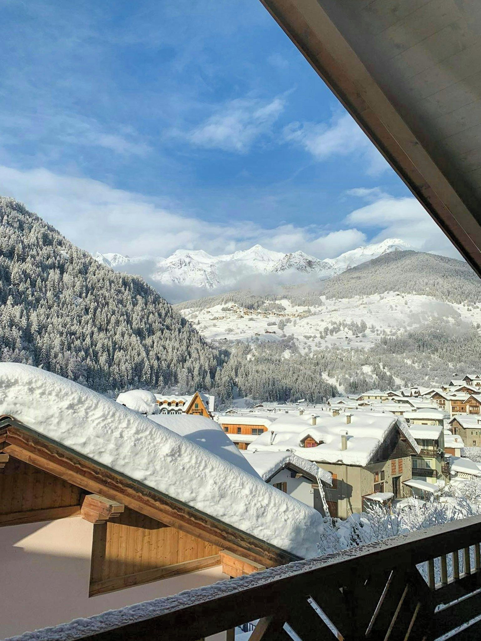 Eine verschneite Berglandschaft mit einem Dorf und Häusern.
