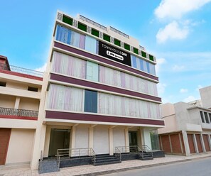 A multi-story building with a sign indicating it is serviced by OYO. - Deluxe Govindpuri Station Formerly Montto Plaza (Kanpur)