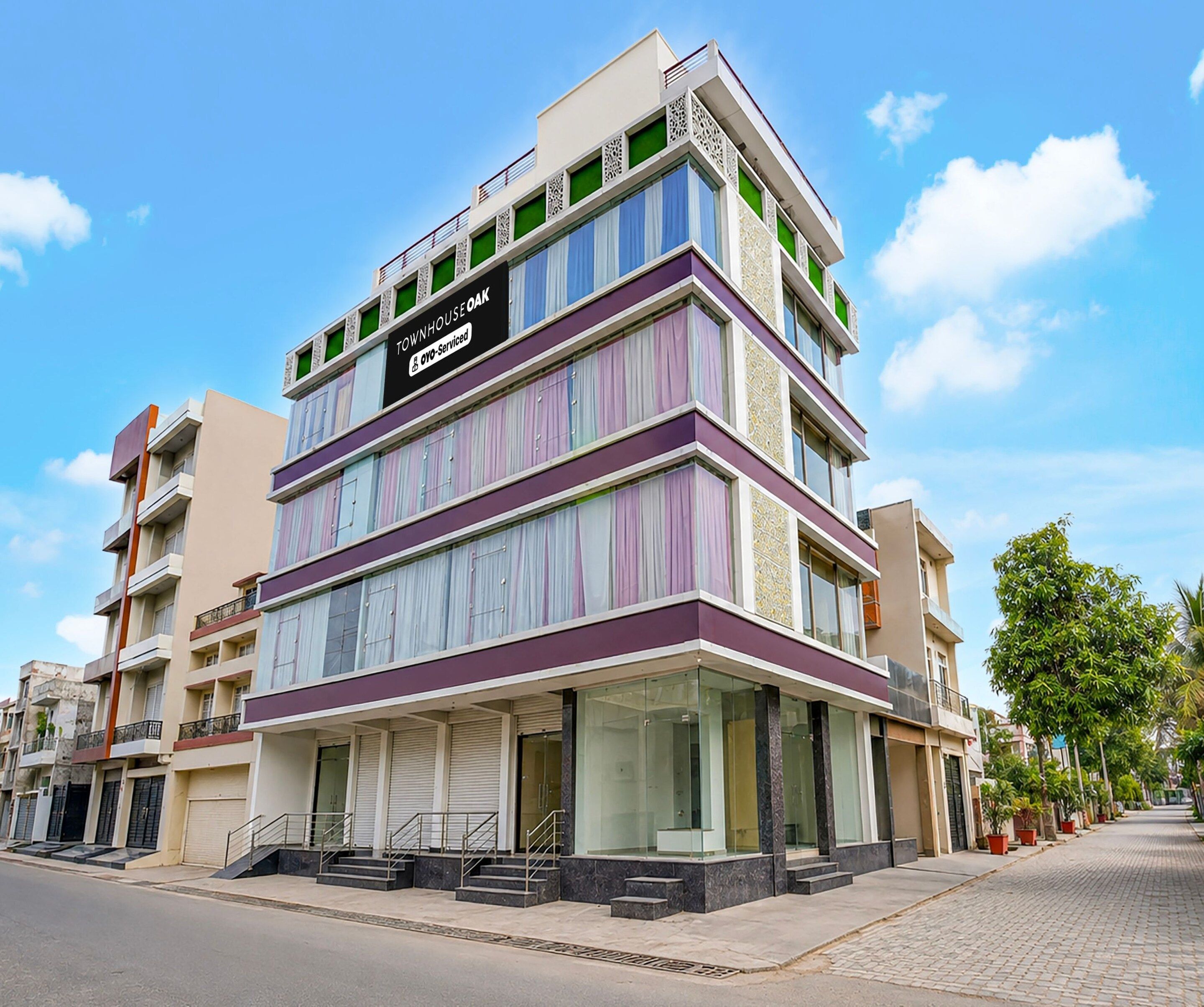 A multi-story building with a prominent sign indicating it is serviced by OYO.