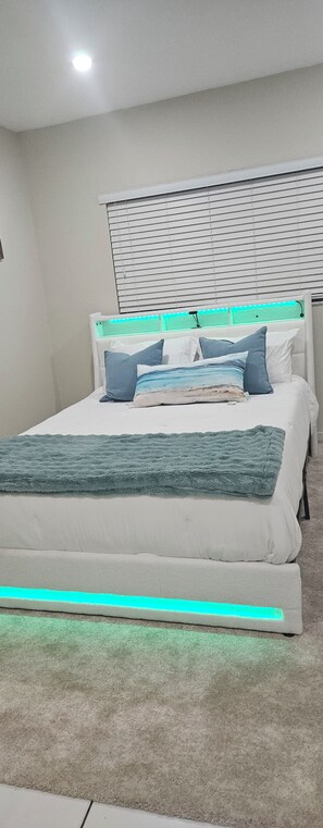 A bedroom with a bed, pillows, a blanket, and a ceiling light. - Gorgeous 1-bedroom house with AC in vibrant Miami,..free parking (Miami)