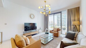 Ein modernes Wohnzimmer mit einem Flachbildfernseher, einem Glastisch und zwei Sofas.