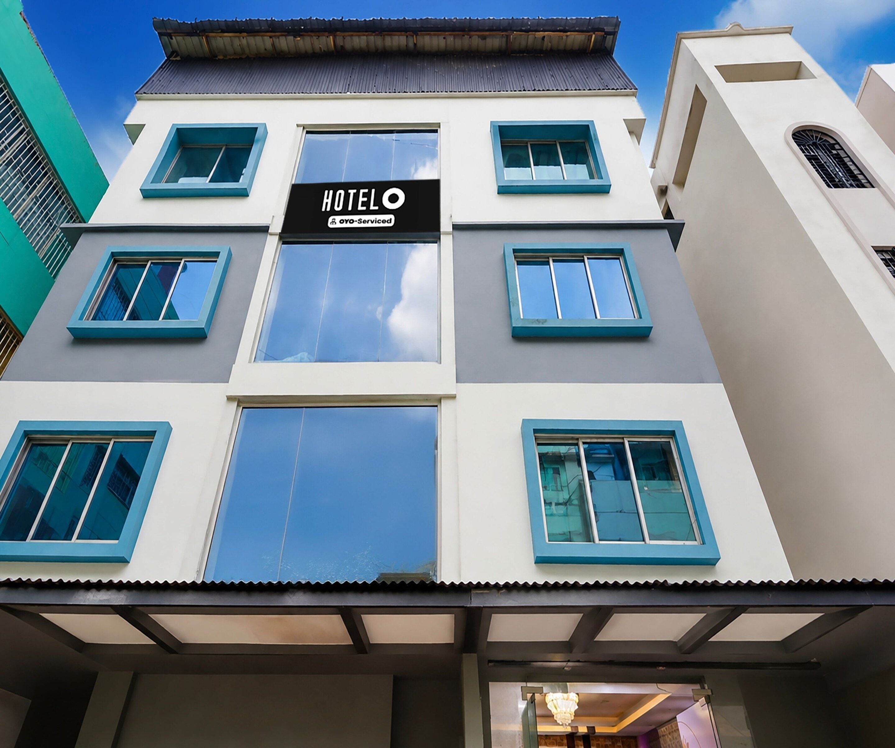 A hotel building with a sign indicating it is serviced by Oyo.
