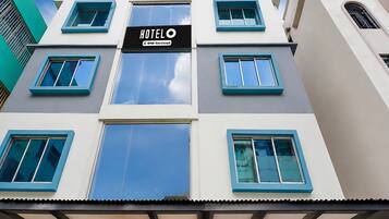 A hotel building with a sign indicating it is serviced by Oyo.