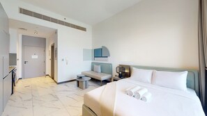 Ein Hotelzimmer mit Bett, einer Couch, einem kleinen Tisch und einem Schreibtisch.