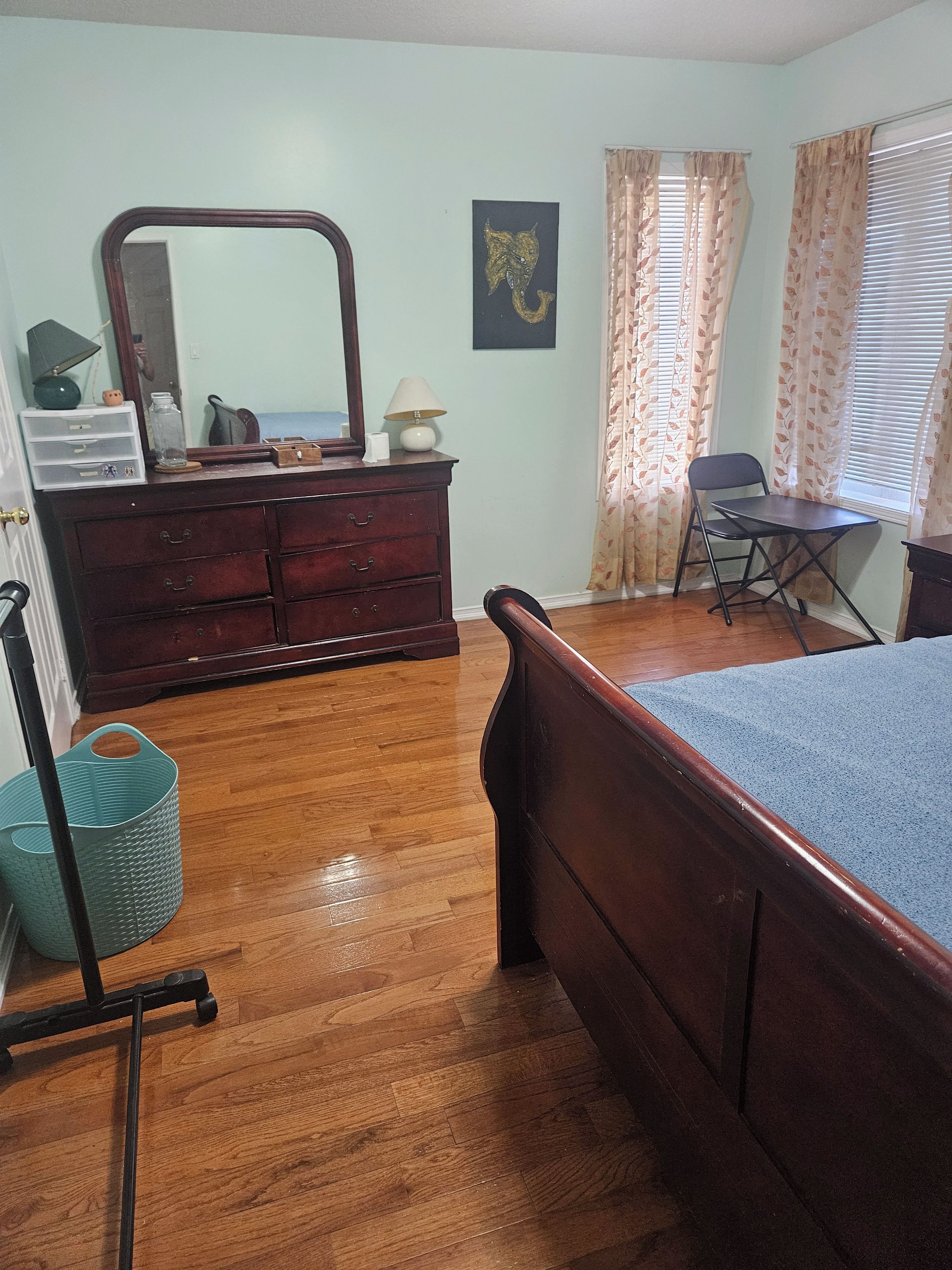 Une chambre à coucher avec un lit en bois, une commode, un bureau et une chaise.