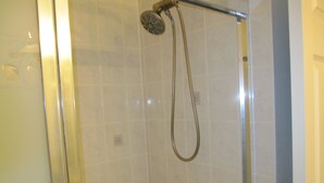 A shower with a handheld showerhead and a wall-mounted faucet. - Cosy Room with exclusive bathroom (Mississauga)