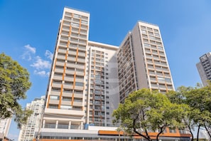 A high-rise residential building with multiple balconies, a modern architectural design, and a clear sky. - Yuny - Zip  Morumbi (São Paulo)