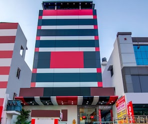 Un edificio de varios pisos con un diseño arquitectónico moderno, que presenta un llamativo patrón a rayas verticales en la fachada.