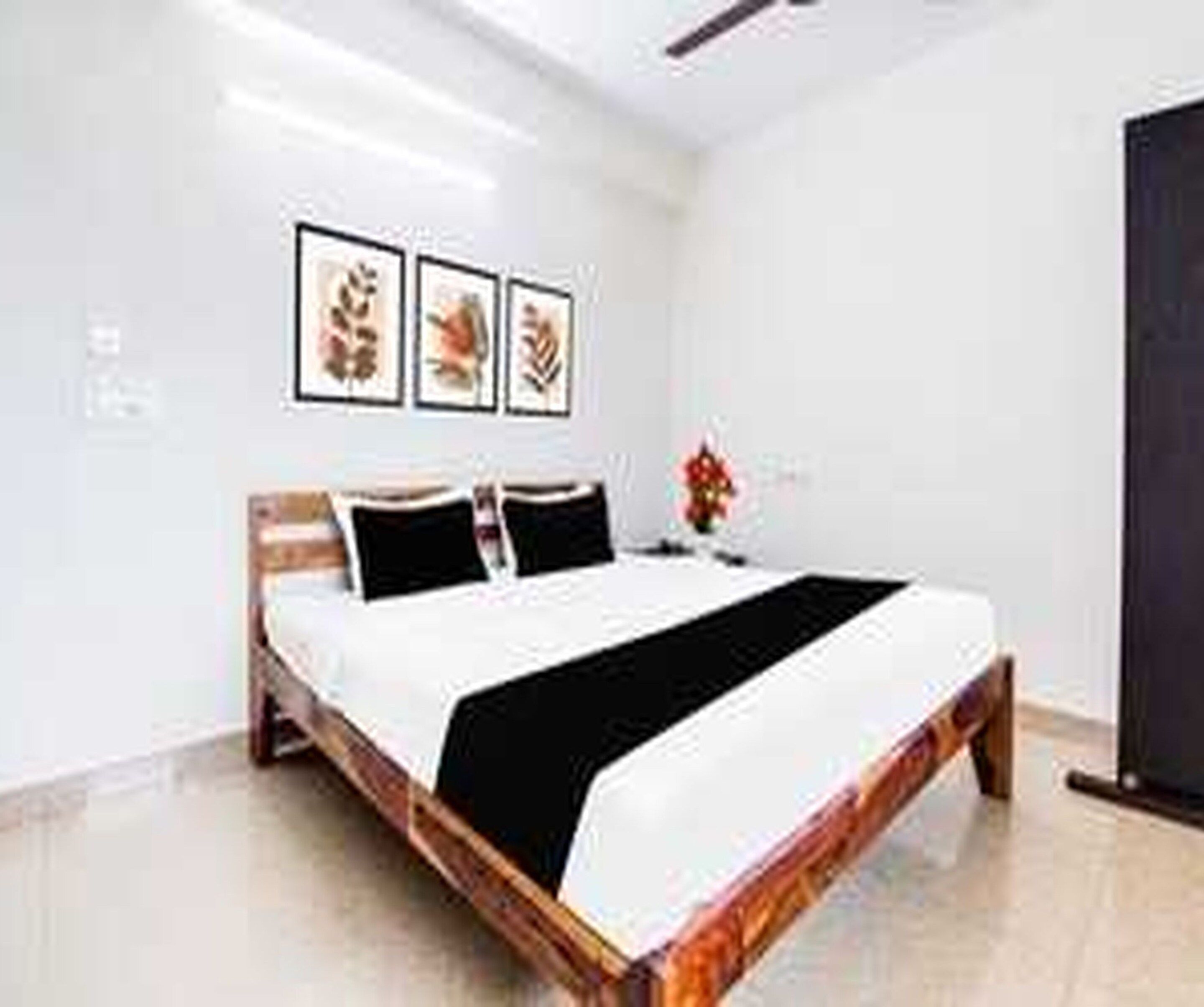 A hotel room with a bed, a nightstand, and wall-mounted artwork.