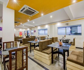 Un restaurante con cabinas y mesas, aire acondicionado y un techo luminoso.