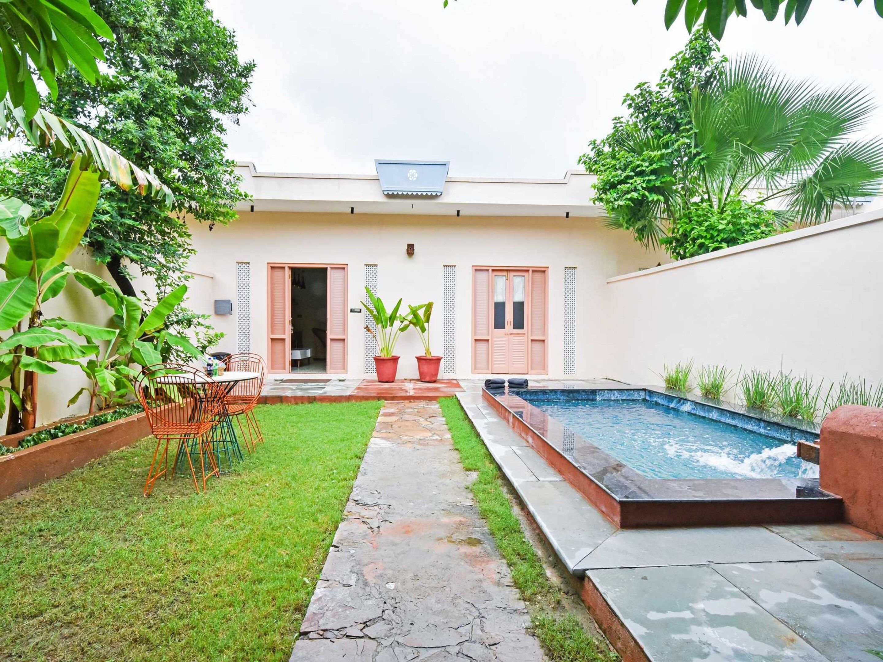A residential property with a swimming pool, a small lawn, and a patio area.