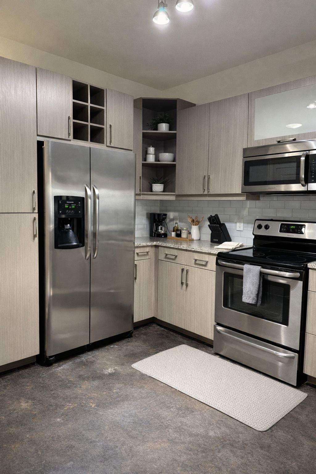 A modern kitchen with stainless steel appliances, including a refrigerator, microwave, and oven.