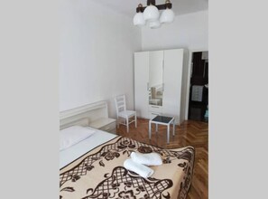Ein Schlafzimmer mit einem Bett, einem Sessel, einem kleinen Tisch und einem Kleiderschrank.
