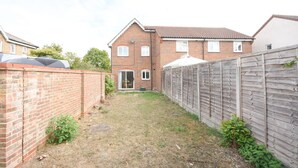 A brick house with a fenced backyard, a garage, and a small garden area. - Beautiful 3BRHome with a large garden in Colchester (Colchester)