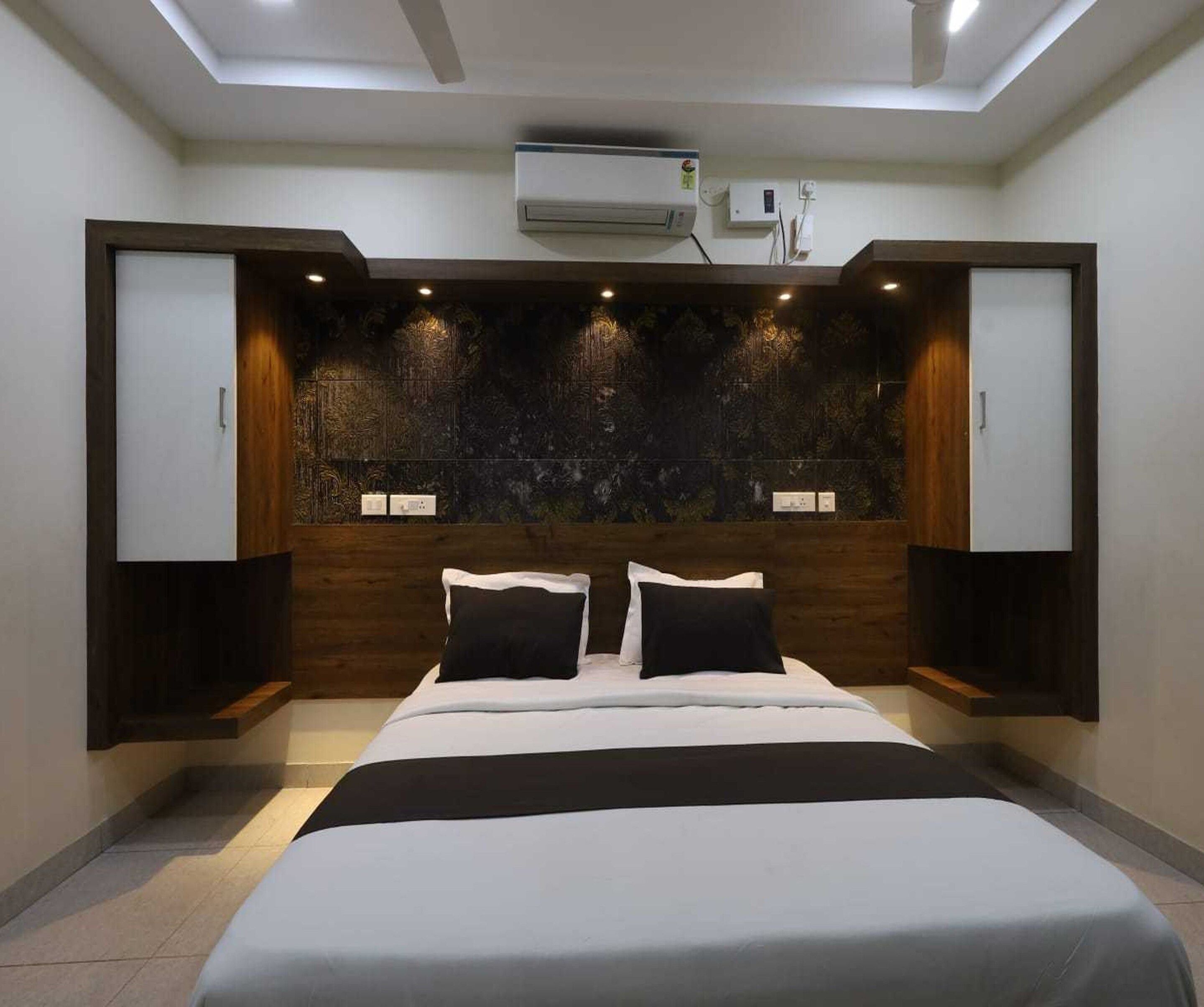A modern bedroom with a bed, built-in wardrobe, and an air conditioning unit.
