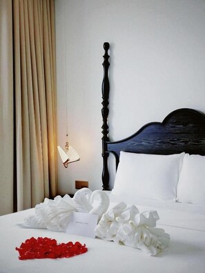 A hotel room with a bed, a nightstand, a wall-mounted fan, and a curtain. - The Eden Cat Ba (Cat Hai)