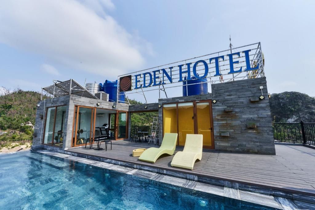 A modern hotel with a pool, lounge chairs, and a sign reading 'EDEN HOTEL'.