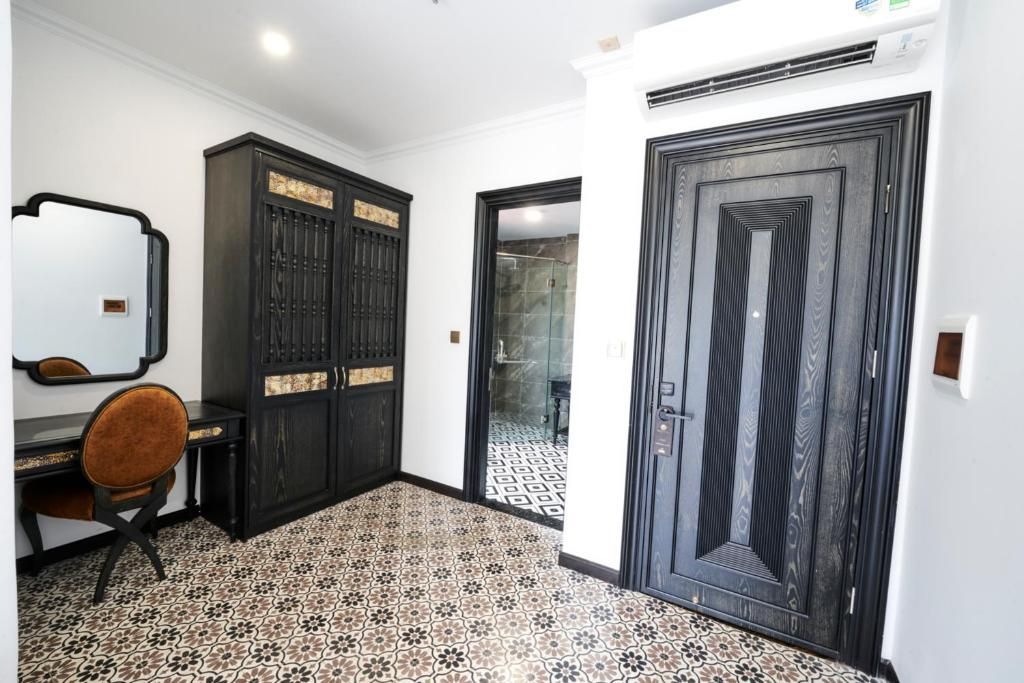A room with a desk, chair, wardrobe, and a door.