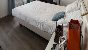 Ein Hotelzimmer mit Bett, Schreibtisch, Stuhl und einem Bild an der Wand.