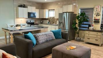 A modern kitchen with white cabinets, stainless steel appliances, and a central island.