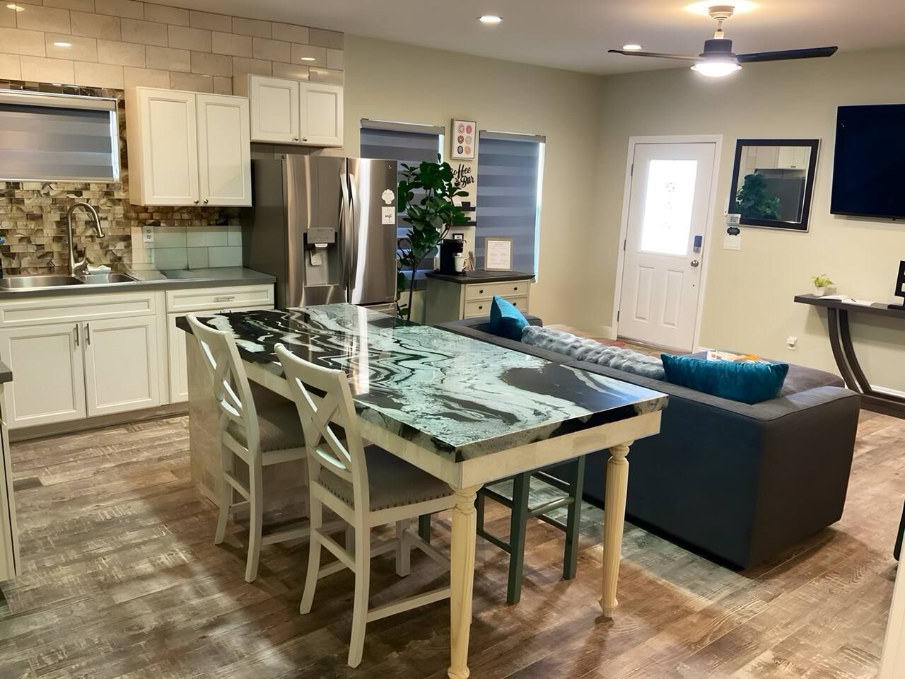A kitchen with a central island, white cabinets, and a built-in oven.