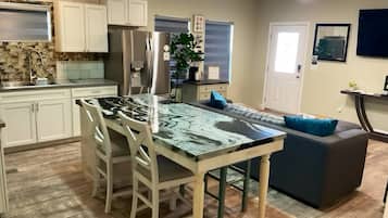 A kitchen with a central island, white cabinets, and a built-in oven.