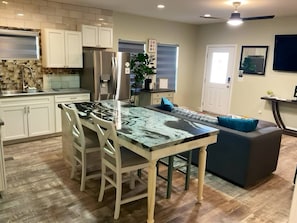 A kitchen with a central island, white cabinets, and a built-in oven.