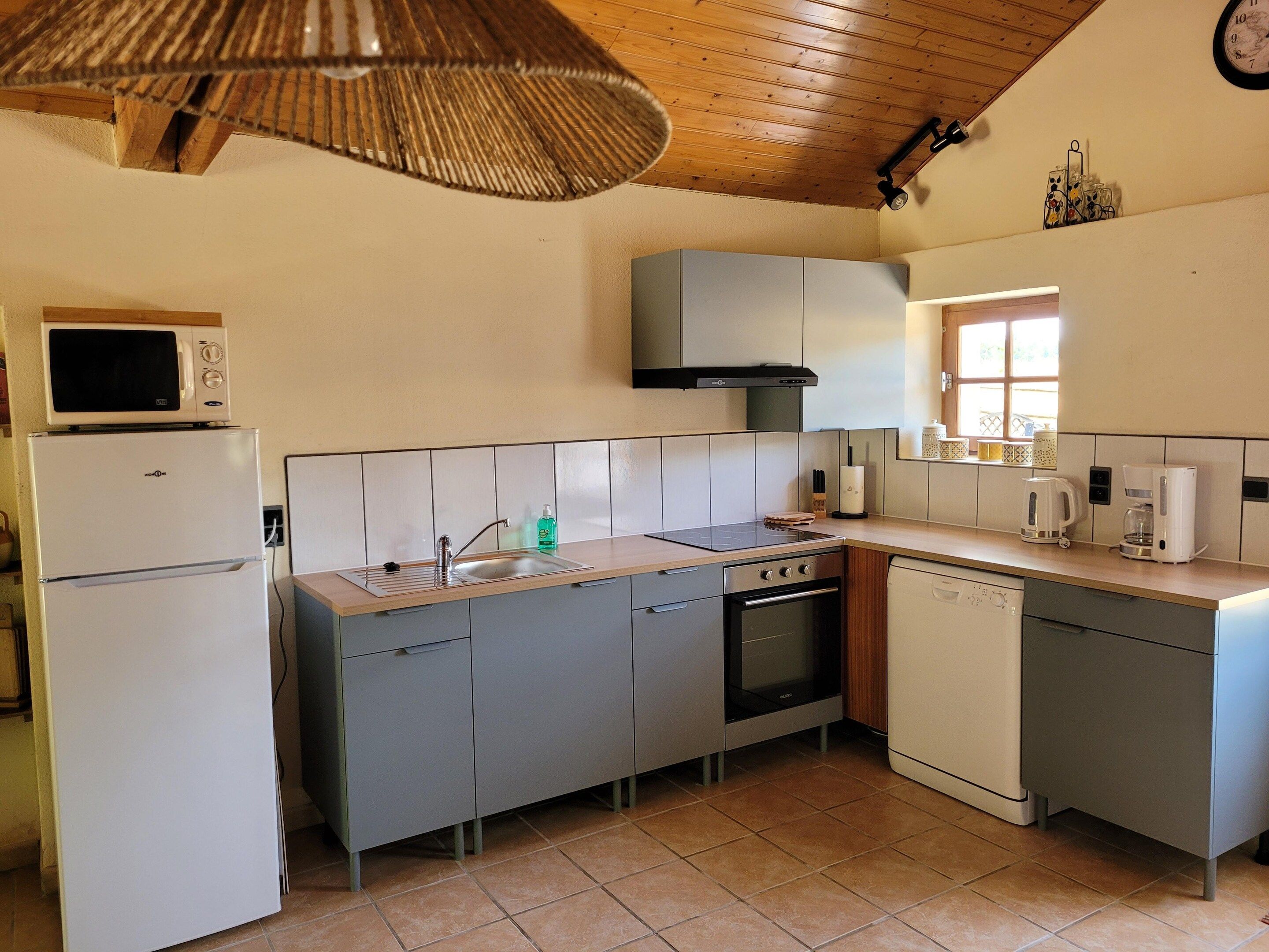 A compact kitchen with a microwave, sink, stove, and dishwasher.