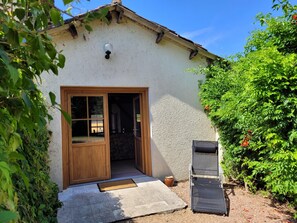 Ein Gebäude mit einer Holztür, einer kleinen Veranda und einem Fenster.