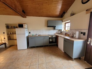 A compact kitchen with a refrigerator, stove, sink, and cabinets. - Gite With Garden and Shared Pool (Saint-Saud-Lacoussiere)