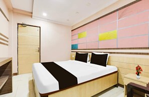 A hotel room with a bed, bedside table, and a wall with a colorful design. - Hotel O Pedagantyada Gajuwaka (Visakhapatnam)