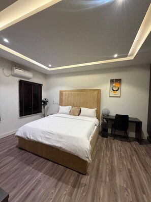 Ein modernes Schlafzimmer mit einem hölzernen Bett, einem Schreibtisch und einem Stuhl.