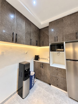 A modern kitchen with built-in appliances, grey cabinetry, and a coffee machine. - 3 BEDROOM APARTMENT IN LIFECAMP GWARINPA ABUJA (abuja)