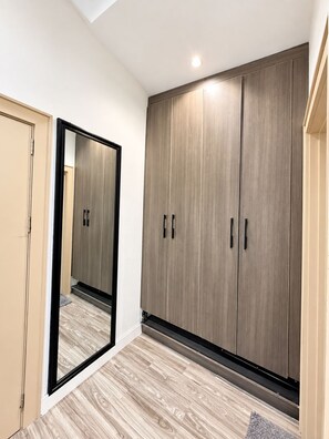 A room with a large wardrobe, a mirror, and a wooden floor. - 3 BEDROOM APARTMENT IN LIFECAMP GWARINPA ABUJA (abuja)