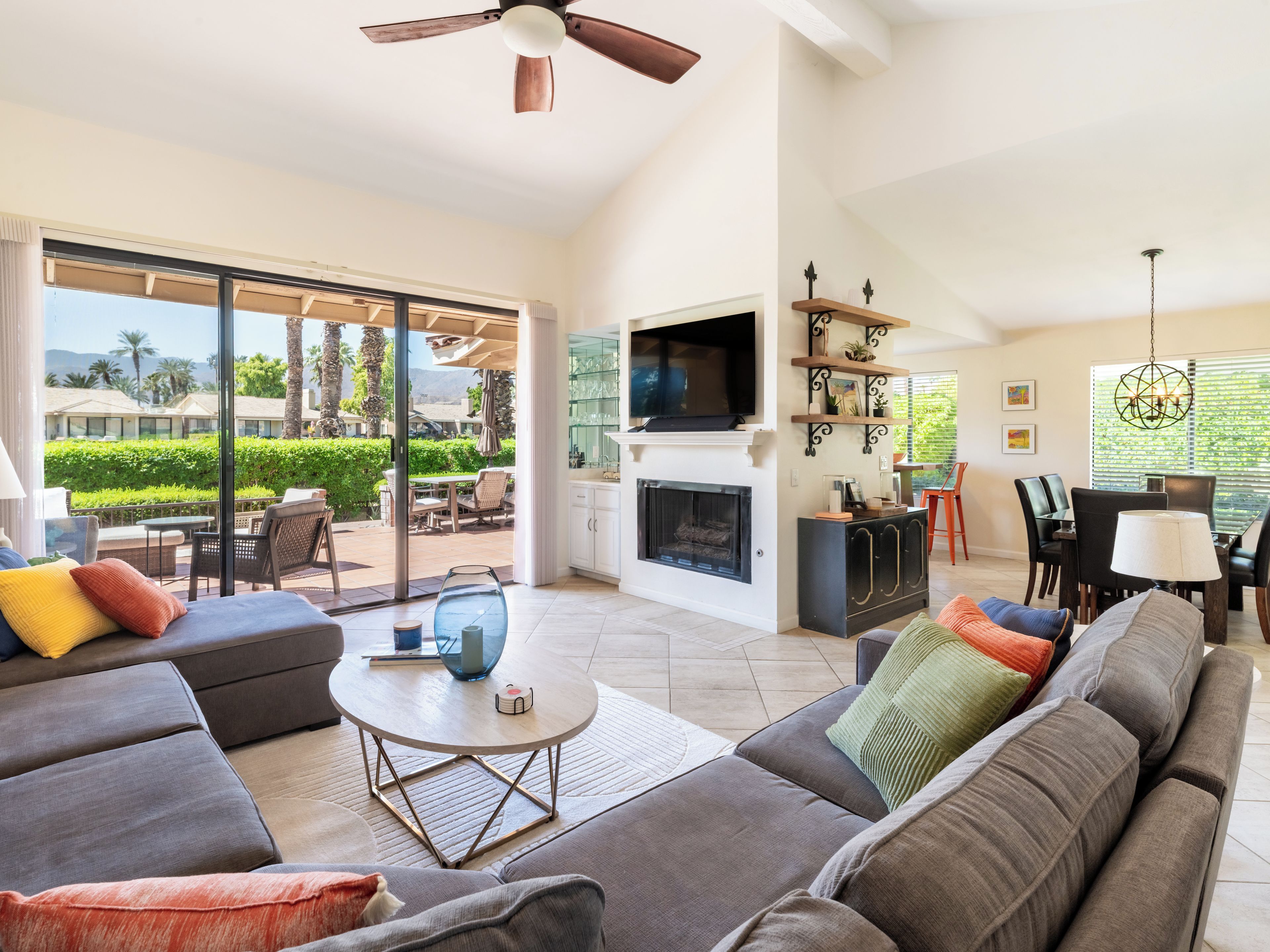 Amplia sala de estar con chimenea, televisor y comedor con mesa y sillas.
