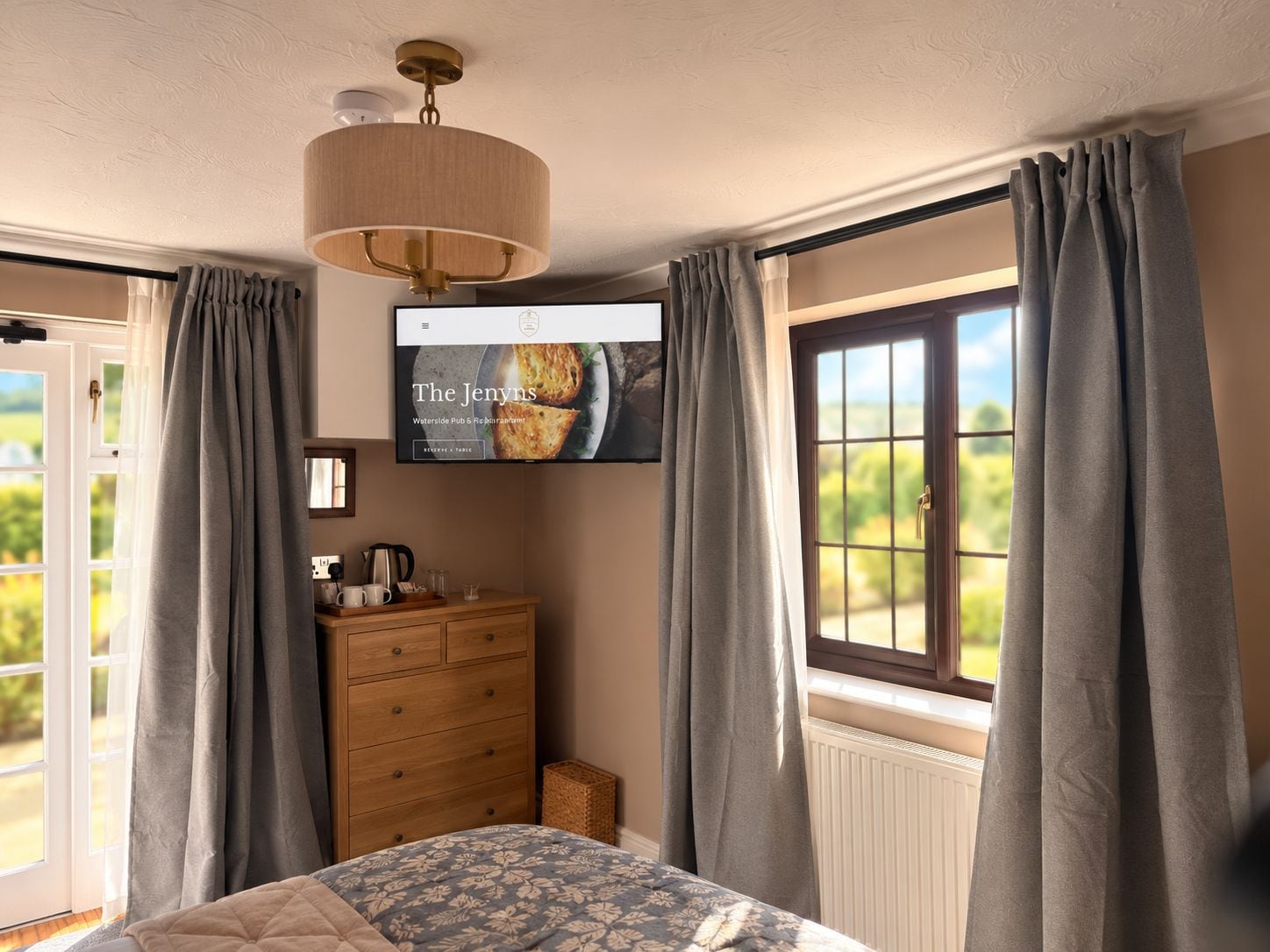 Un dormitorio con cama, cómoda y televisor en la pared.
