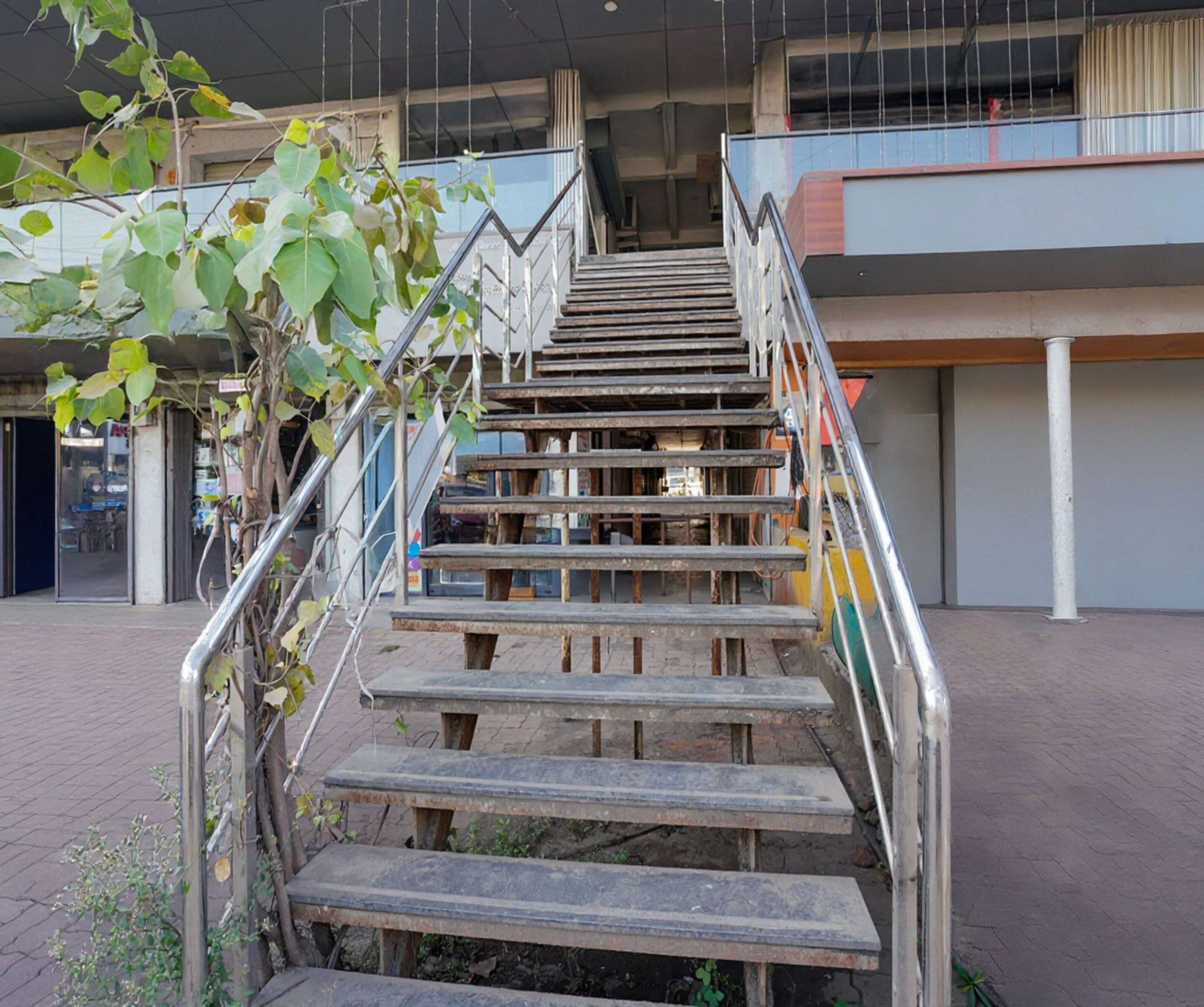 Una escalera con barandillas de metal que lleva a la entrada de un edificio.