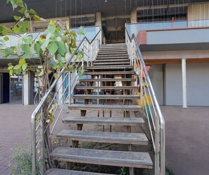 A staircase with metal railings leading to a building entrance. - Deluxe With Twin Bed (Vapi)