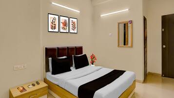 A modern bedroom with a wooden bed frame, a nightstand, a bedside table, and a wall-mounted mirror.