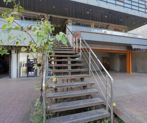Una escalera que lleva a un nivel superior de un edificio, con barandilla de metal.
