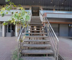 A staircase with metal railings leading to an entrance of a building.