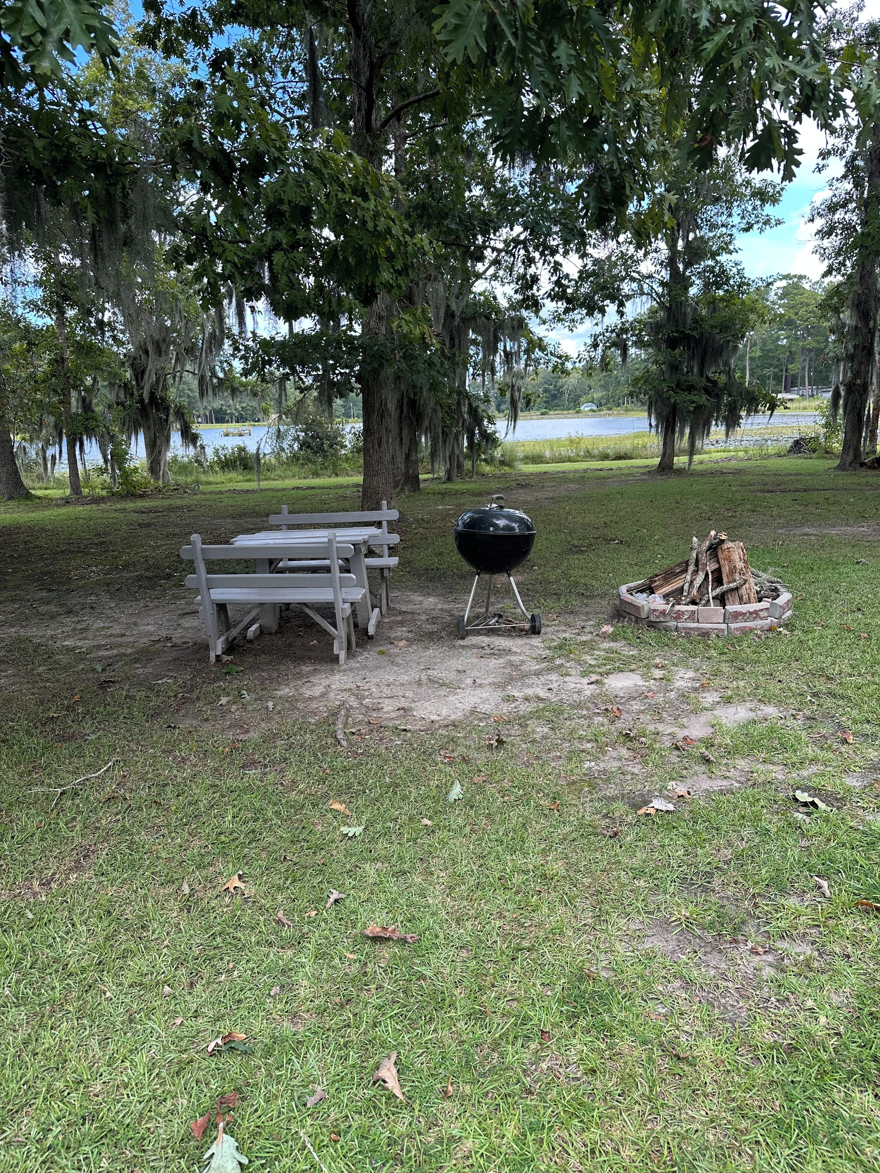 Un área de picnic con banco, parrilla y fogata.