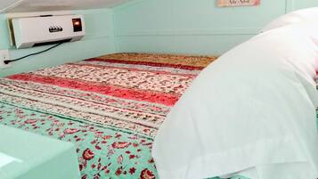 A room with a bed, a wall-mounted air conditioner, and a sign with text.