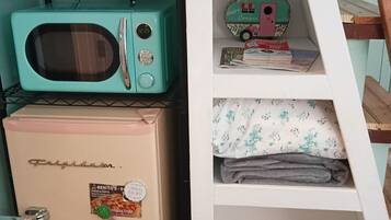 Una kitchenette equipada con microondas, tostadora y refrigerador.