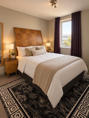 A hotel room with a large bed, two bedside tables with lamps, a geometric-patterned rug, and a window with curtains. - Birmingham City Cente | Penthouse Balcony Views (Birmingham)
