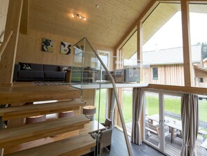 A wooden interior with a staircase, a sofa, and a view of the outdoors. - Cabin With 1 Bedroom (Sankt Georgen am Kreischberg)