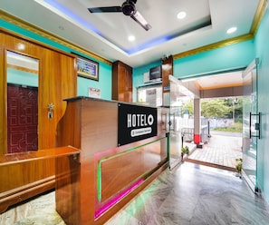 A hotel reception desk with a sign indicating it is company-serviced. - Classic Hotel Jaisas Paradise (Nagercoil)