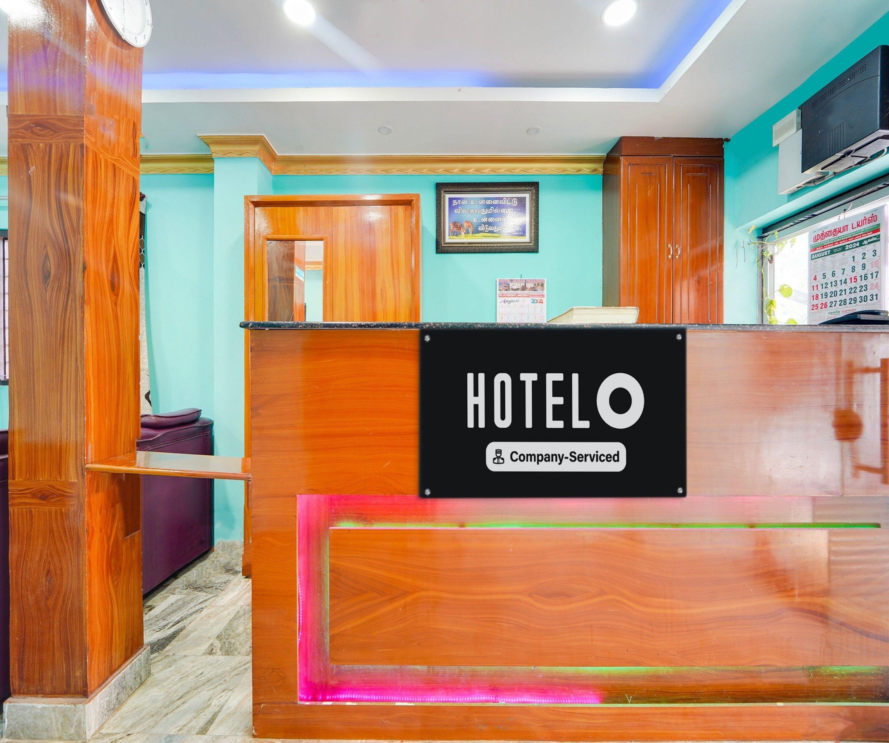 A hotel reception desk with a sign indicating it is company-serviced.