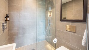 Une salle de bain moderne avec une douche à parois de verre, des toilettes et un lavabo.